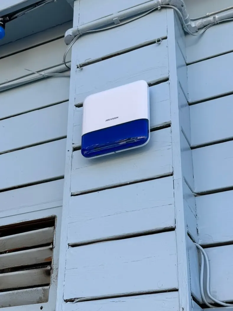 Hikvision external alarm sounder mounted on painted timber cladding